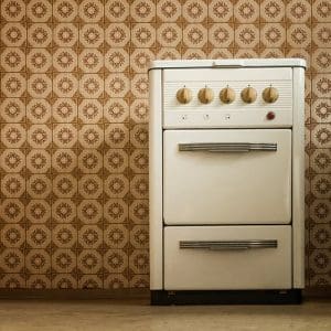 stove in old kitchen standing in front of pvc wallpaper